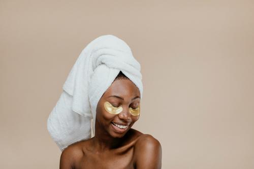 Happy black woman wearing a golden eye mask - 1203344