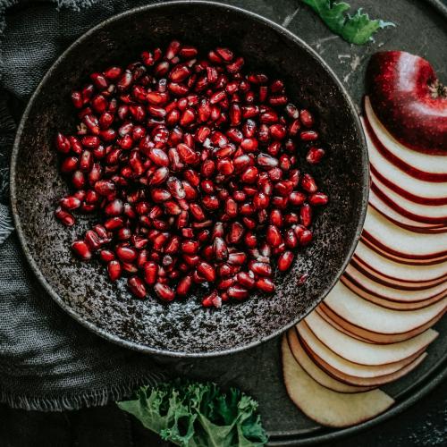 Closeup of fresh pomegranate with sliced apple food photography - 1054344