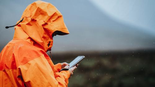 Woman using her mobile phone in the highlands - 1077891