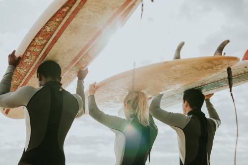 Happy friends surfing at the beach - 1079709