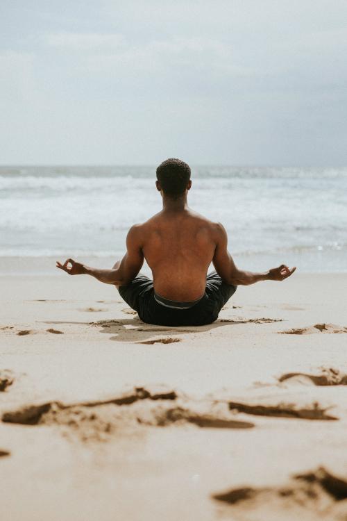 Black man meditating at the beach - 1079724