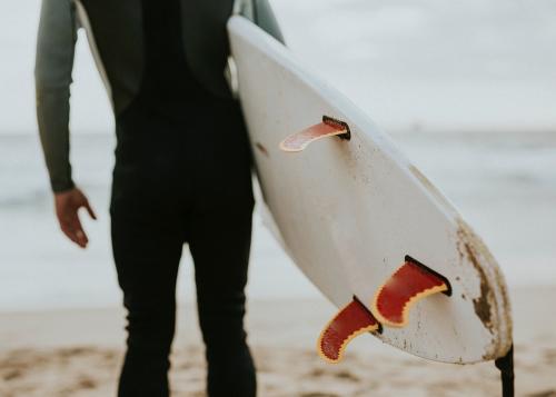 Man at the beach with his surfboard - 1079802