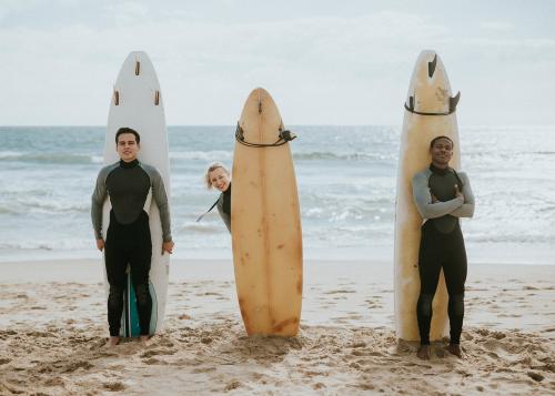 Happy friends surfing at the beach - 1079832