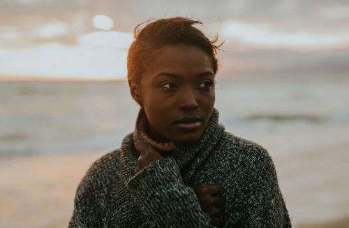 Black woman on the beach at sunset - 1079858