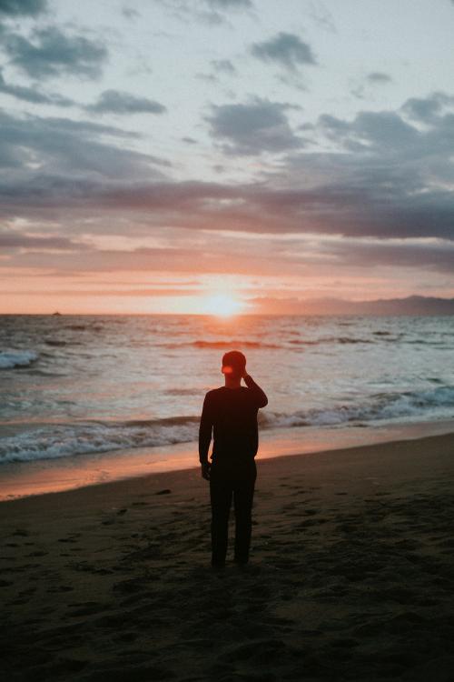 Man watching the sunset on the beach - 1079875