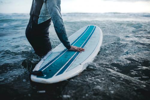 Man at the beach with his surfboard - 1079903