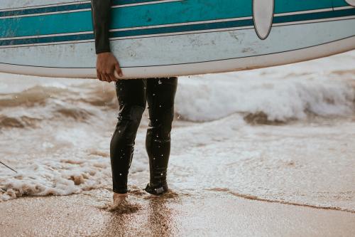 Man at the beach with his surfboard - 1079923