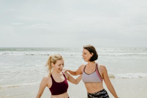 Happy women stretching at the beach - 1079960