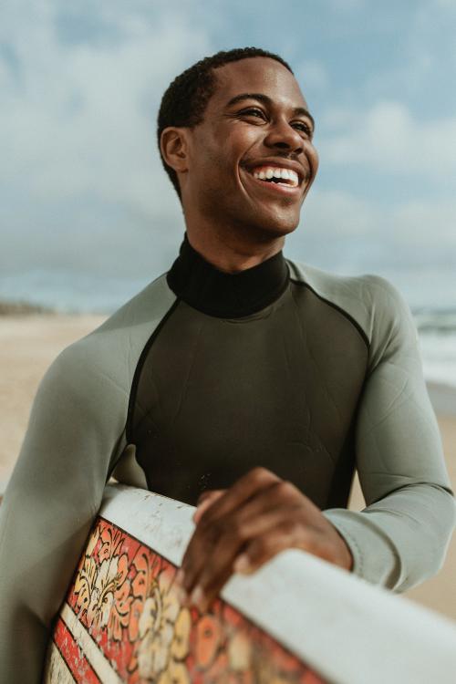 Cheerful man with a surfboard at the beach - 1079975