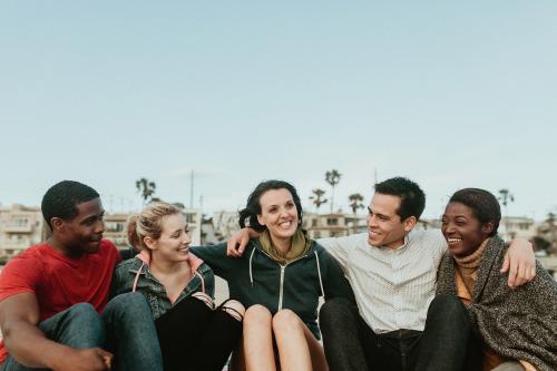 Cheerful friends hugging on the beach - 1080008