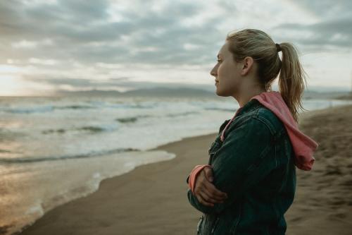 Woman on a gloomy beach - 1080053