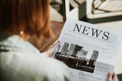 Woman reading a newspaper in a cafe - 1198733