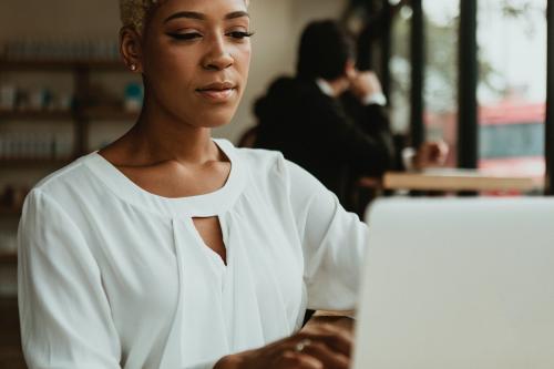 Businesswoman in a cafe using her laptop - 1199604