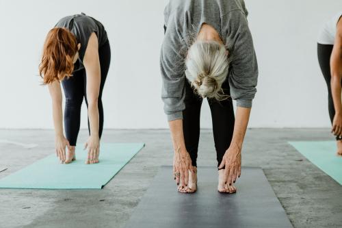 Sporty people practicing Uttanasana pose - 1201721