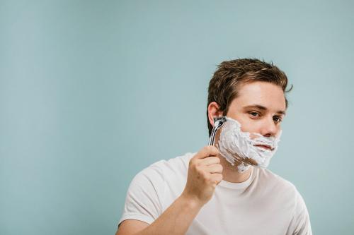 Young man shaving his beard - 1203290