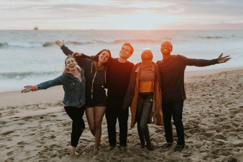 Happy friends enjoying the beach at sunset - 1079774