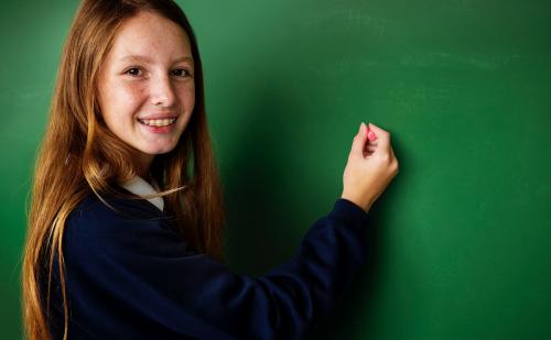 Teenage girls writing on whiteboard - 6334