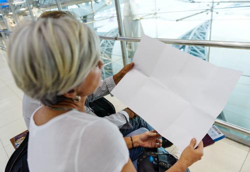 Senior couple looking at blank paper airport - 6399