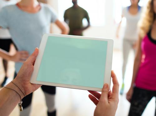 Closeup of a tablet copyspace and diverse people in an exercise class as a background - 5901