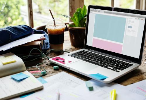 Laptop on a desk with research papers - 6069