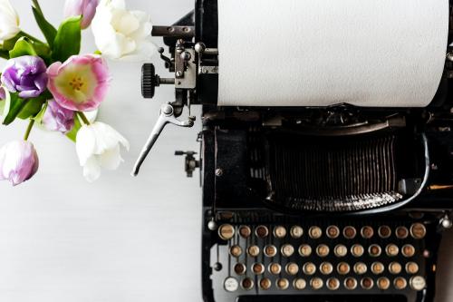 Retro Typewriter Machine with Paper by Flowers in Vase - 6145