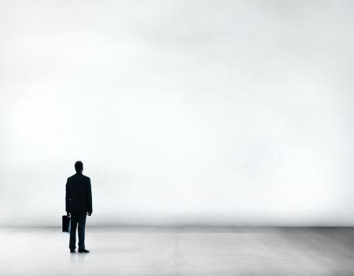 Silhouette of a businessman looking up at a wall - 5398