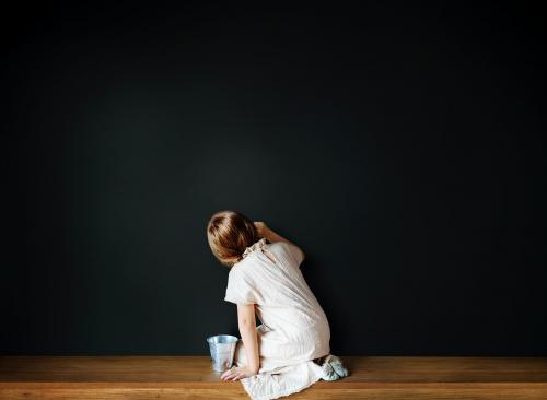 Little girl drawing on an empty black wall - 5429