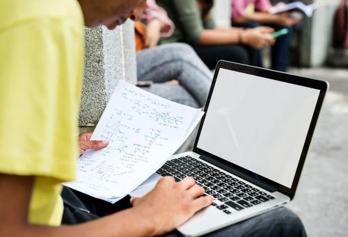 Student doing homework on his laptop - 5513