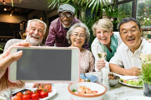 Senior friends in a restaurant taking pictures together - 5515