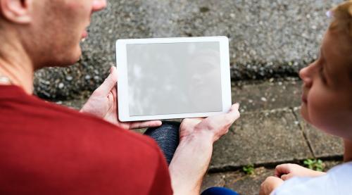 Man showing a kid a tablet mockup - 5837