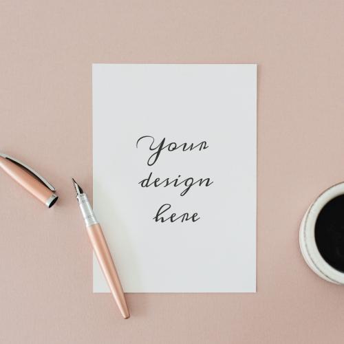 White paper mockup by a coffee cup on a pink table flatlay - 1215230