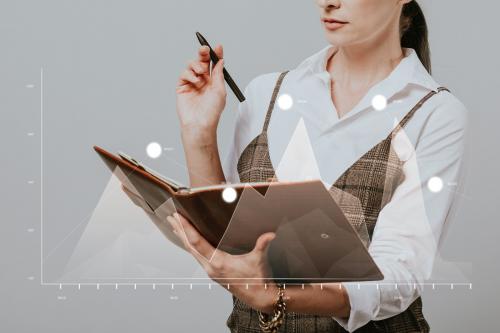 Businesswoman holding a personal notebook and a pen - 1217915