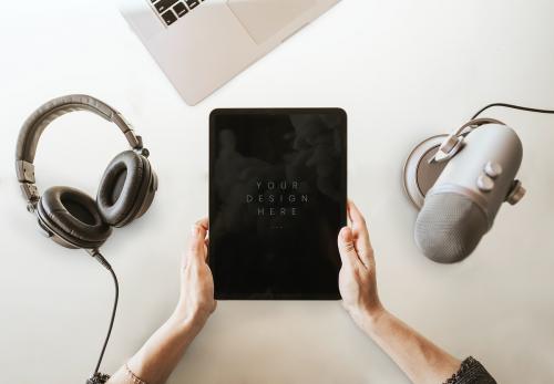 Woman holding a tablet screen mockup by a microphone - 1225490