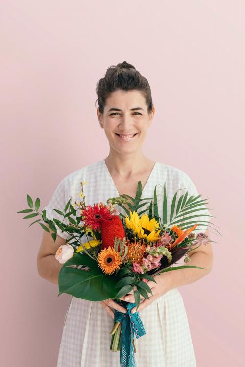 Smiling woman holding a tropical bouquet - 1207468