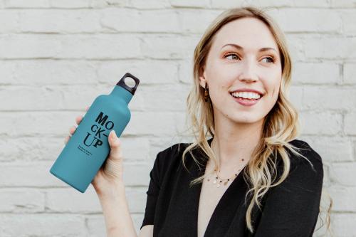 Happy woman carrying a thermal bottle mockup - 1208354