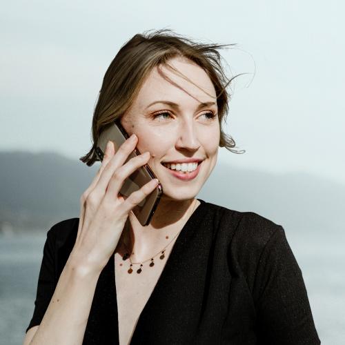 Happy woman talking on a phone mockup by the beach - 1208412