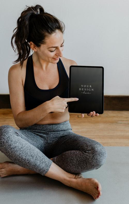 Yoga instructor showing a digital tablet mockup - 1210066