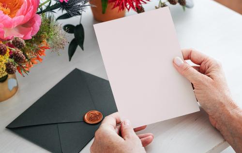 Woman reading an invitation card mockup - 1210202