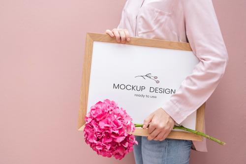 Girl holding a frame mockup with pink hydrangeas - 1210234