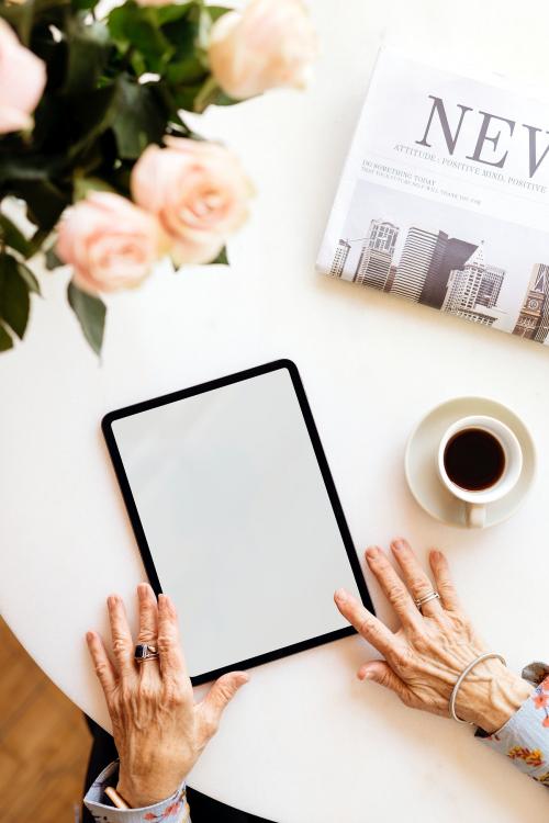 Old woman using a digital tablet in a cafe mockup - 2030422