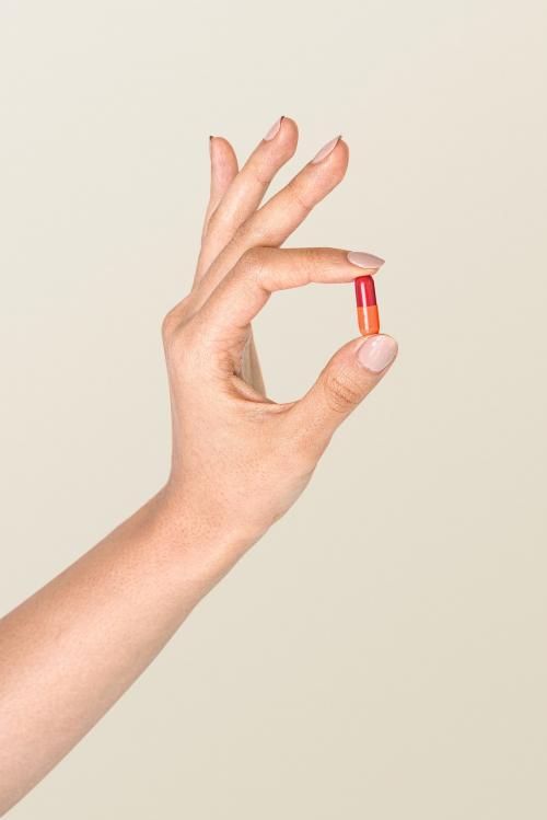 Hand holding a colorful pill mockup - 2052982