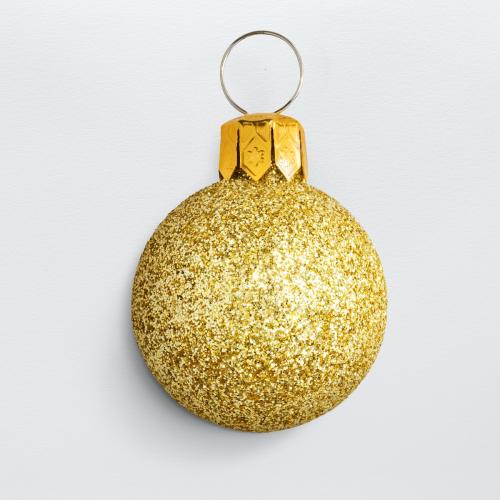 A glitter gold ball Christmas ornament isolated on gray background - 1231248