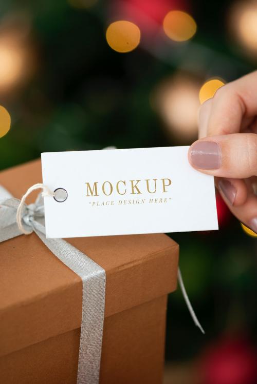 Woman holding a brown present with a white card mockup - 1231769