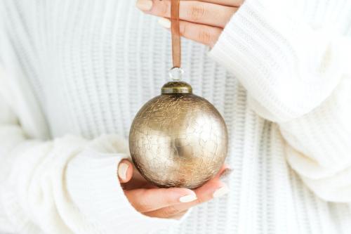 Woman in a white sweater holding a gold bauble mockup - 1231903