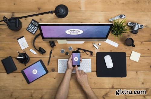 User with Desktop Computer, Tablet, and Smartphone on a Cluttered Wooden Table Mockup 2 124766571