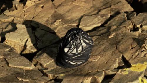 Videohive - Black Trash Bag Lay on a Rocky Beach - 39648114 - 39648114