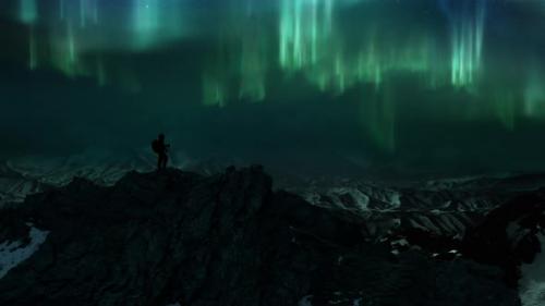 Videohive - Man on Icy Rock Summit of Snowy Mountain Panorama Watching Polar Lights Aurora Borealis - 41886108 - 41886108