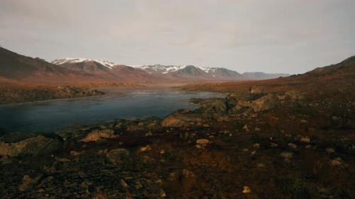 Videohive - Clear River with Rocks Leads Towards Mountains Lit By Sunset - 43264143 - 43264143