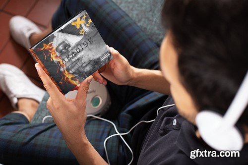 Mockup of a Man Holding a Digipak While Listening SAA8QJG