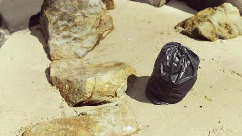 Videohive - Black Plastic Garbage Bag Full of Trash on the Beach - 47639498 - 47639498